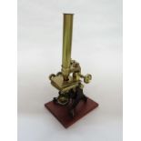 A late 19th Century brass Swift monocular microscope with single eye piece and two objective lenses,