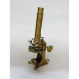 An early 20th Century brass monocular microscope with two eye pieces and two objective lenses,