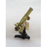 A late 19th/early 20th Century brass and lacquered metal monocular microscope, no maker's name,