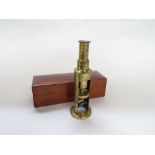 A late 19th/early 20th Century compact brass monocular field microscope of telescopic form,