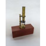 A late 19th/early 20th Century brass monocular field microscope, adjustable tube, single lens,