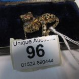 A gold brooch of a leopard set rubies an