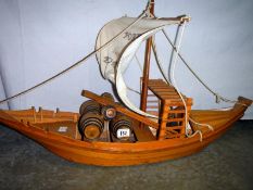 A large wooden replica boat with barrels