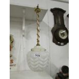 A brass and copper hanging ceiling light with art deco glass shade