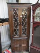 An oak leaded glazed corner cupboard