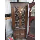 An oak leaded glazed corner cupboard