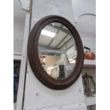 A oval wood framed mirror