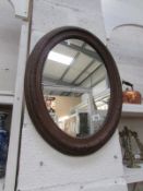 A oval wood framed mirror