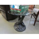 A glass topped occasional table supporte