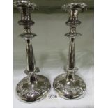 A pair of ornate silver plated candlesti