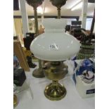 A brass oil lamp with shade but missing chimney