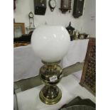 A brass oil lamp with shade but missing
