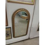 A gilt framed arched mirror