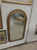 A gilt framed arched mirror