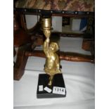 A 19th century bronze cherub candlestick