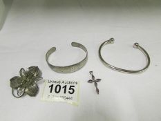 A silver torque bracelet, silver floral engraved bracelet, silver brooch and silver/amethyst cross