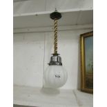 A brass and copper hanging ceiling light with art deco glass shade