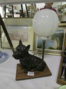 An Art Deco table lamp with a spelter terrier dog