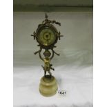 A small clock supported by a Cherub and