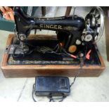 A Singer electric sewing machine with tin of accessories