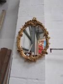 An oval gilt framed mirror
