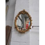 An oval gilt framed mirror