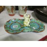 A majolica dish surmounted Cherub and wi