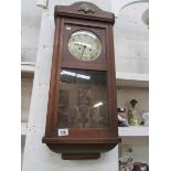 An oak wall clock, missing pendelum and
