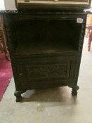 An ebonised carved cabinet