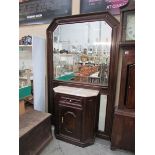 A large hall mirror with marble top cabi