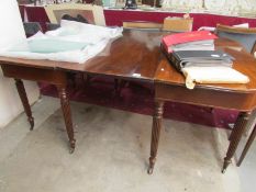 A mahogany extending dining table on ree