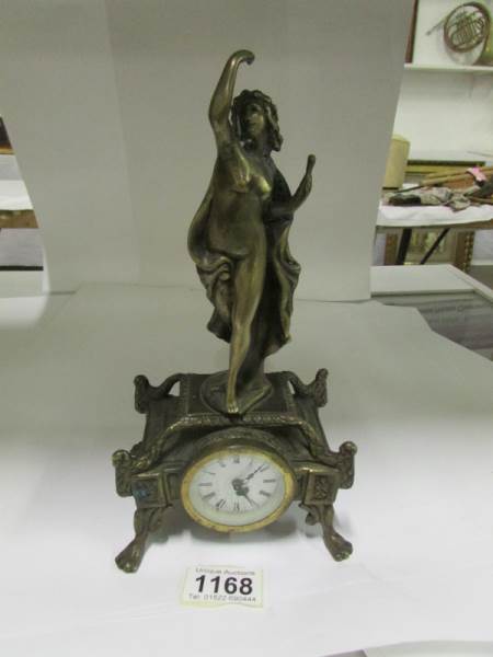 A brass cased clock surmounted art nouve