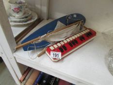 A Hohner Melodica alto and a wooden pond