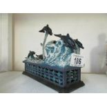 A cast iron mechanical dolphin money box