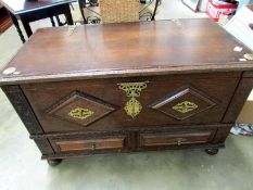 A carved oak mule chest with brass mount