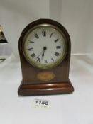 A small mahogany inlaid mantel clock