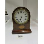 A small mahogany inlaid mantel clock