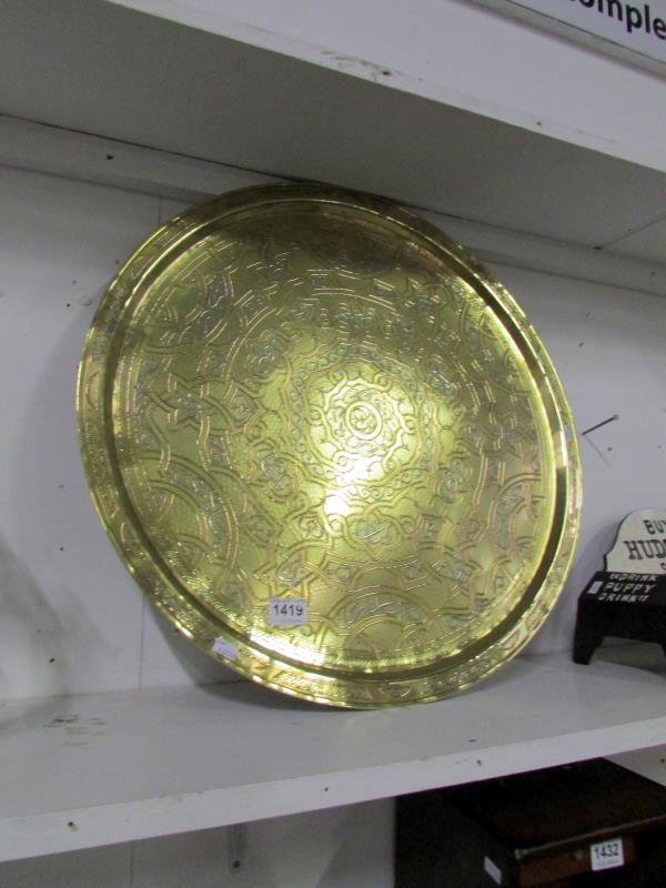A brass tray with copper and silver over