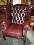 A red leather wing back arm chair