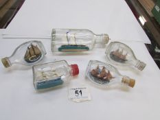 5 miniature ships in bottles