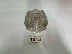 A silver badge, possibly Masonic Grand M