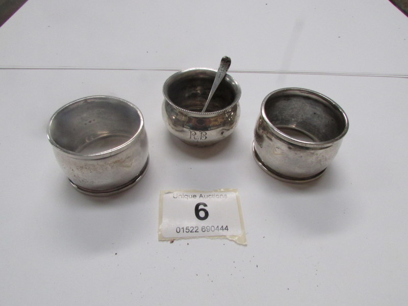 A silver mustard pot with spoon and 2 si