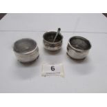 A silver mustard pot with spoon and 2 si