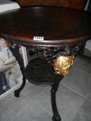 A cast iron pub table with stained wood