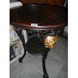 A cast iron pub table with stained wood