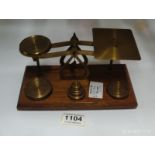 A set of brass postal scales and weights