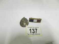 A silver fob and an enamel bar