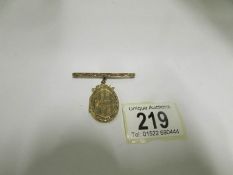 A 9ct gold locket on 9ct gold bar brooch