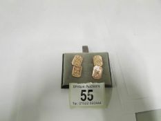 A pair of rose gold cuff links with chas