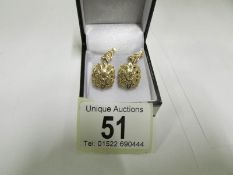 A pair of unmarked gold pendant earrings